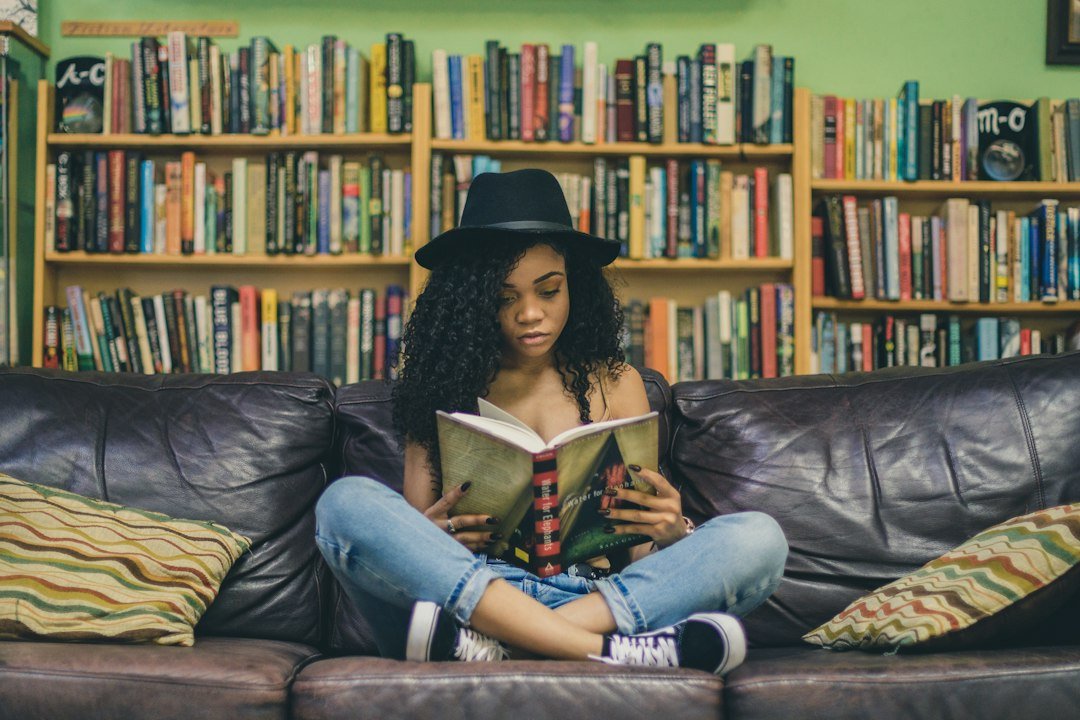 woman reading book couch