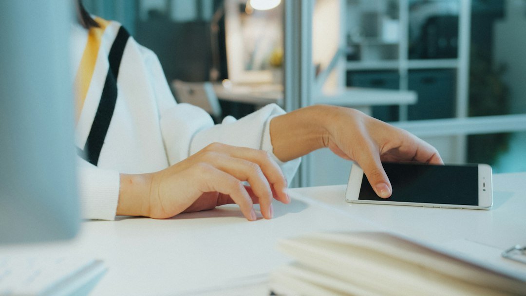 person putting away smartphone desk